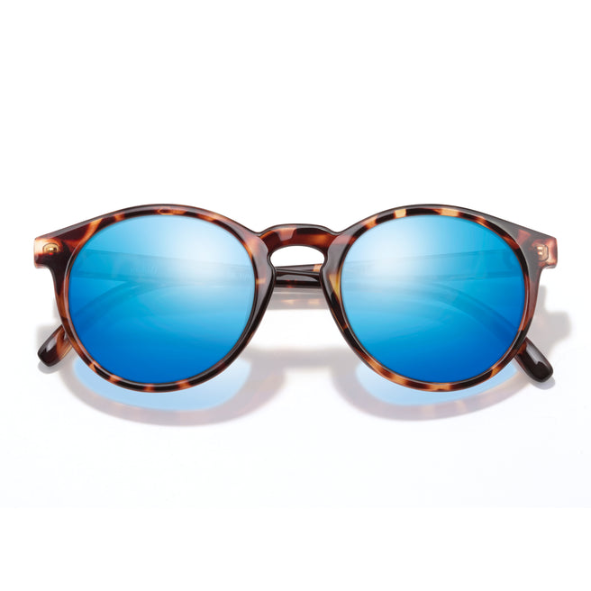 Sunglasses with tortoiseshell frame and blue lenses on a white background
