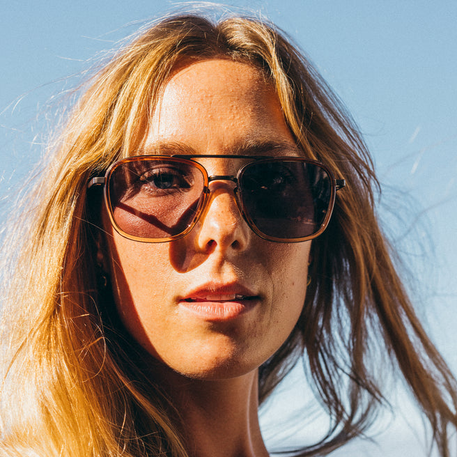 Person wearing sunglasses with a clear blue sky background