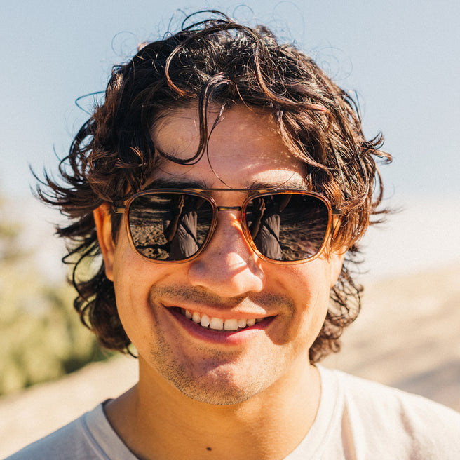 Man wearing sunglasses with a blurred natural background