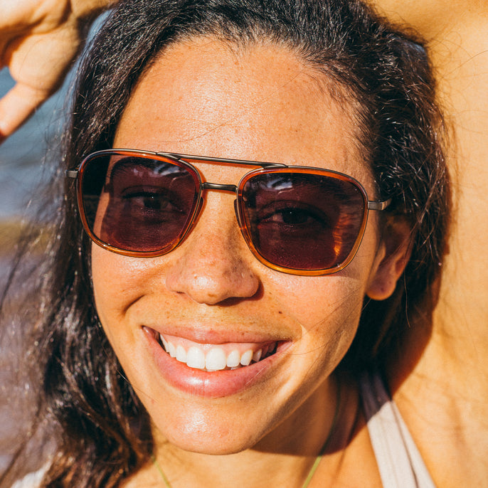 Woman wearing sunglasses with a blurred natural background