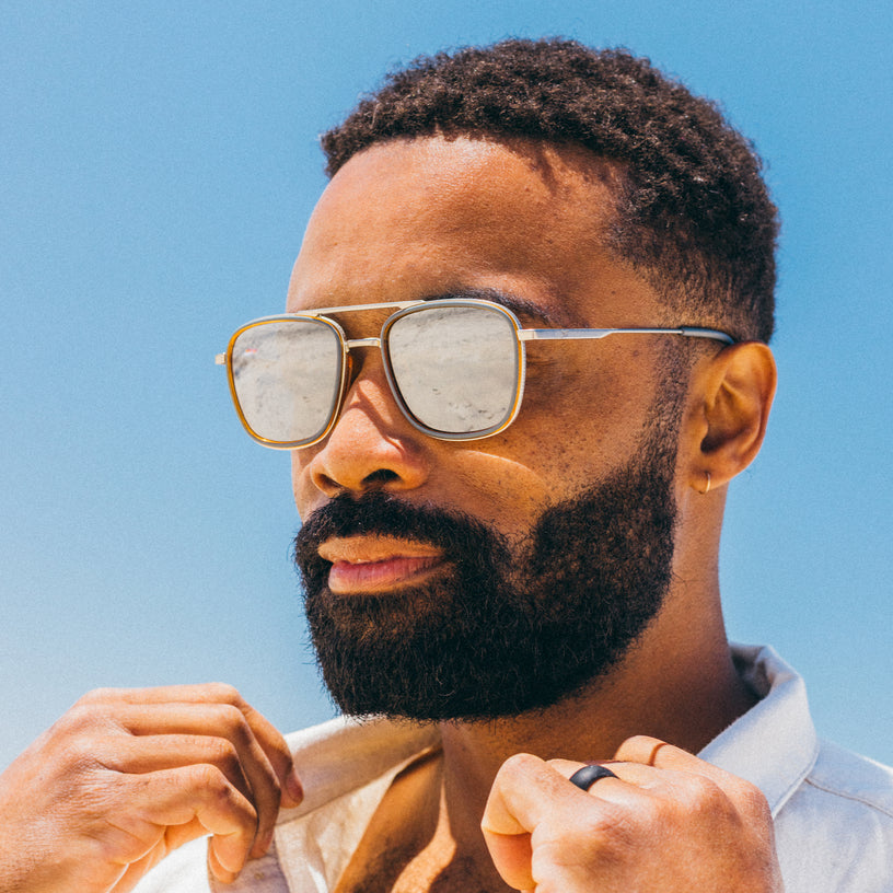 Man wearing sunglasses with a clear blue sky background