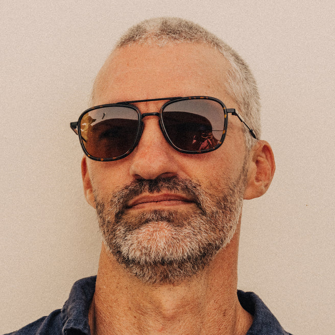 Man wearing sunglasses with a neutral background