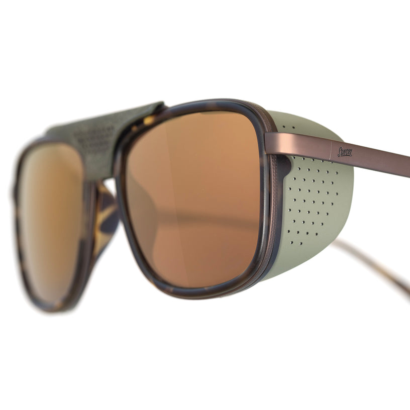 Sunglasses with brown lenses and a green frame on a white background