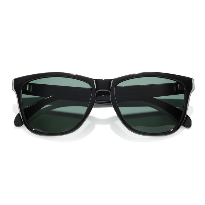 Black sunglasses with green lenses on a white background