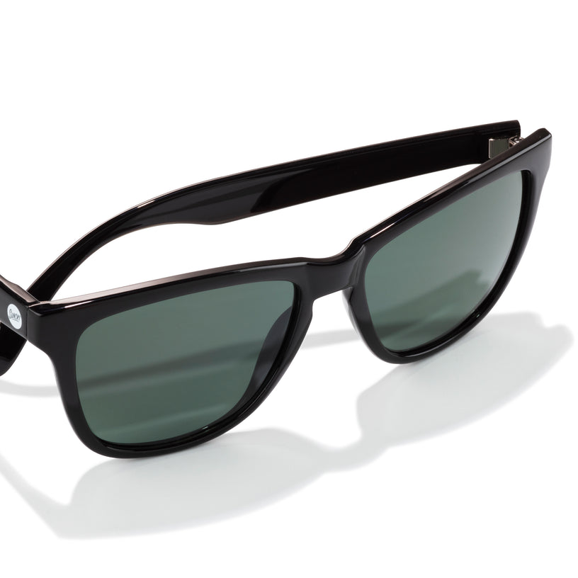 Black sunglasses with dark lenses on a white background