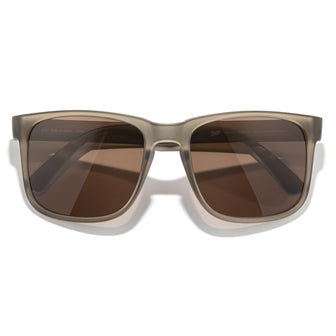 Sunglasses with brown lenses and a beige frame on a white background
