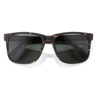 Sunglasses with tortoiseshell frame and dark lenses on a white background