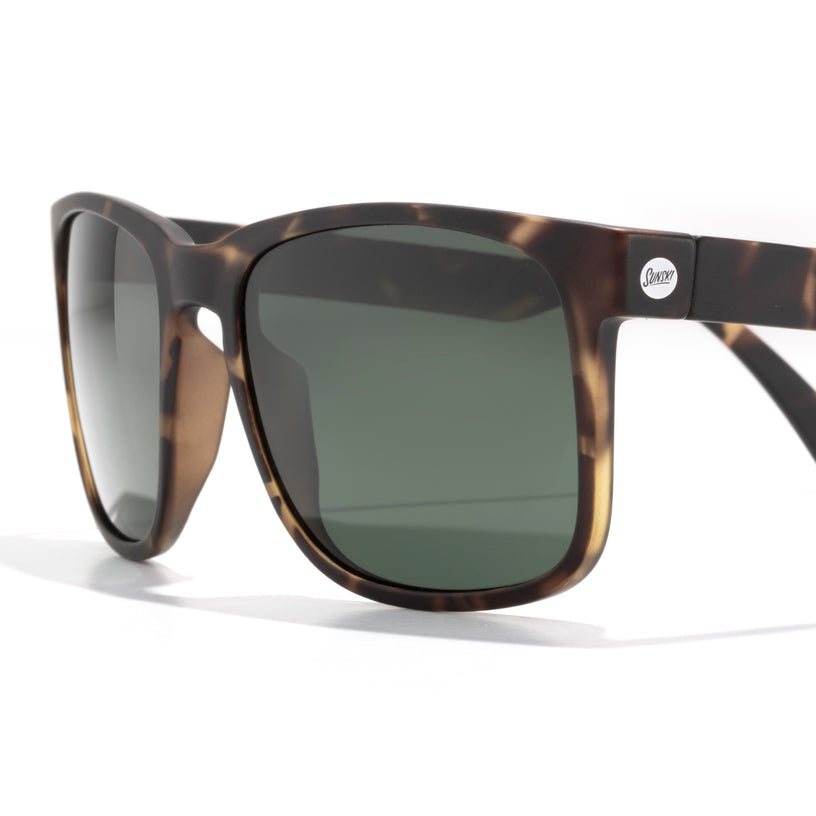 Sunglasses with tortoiseshell frame and dark lenses on a white background