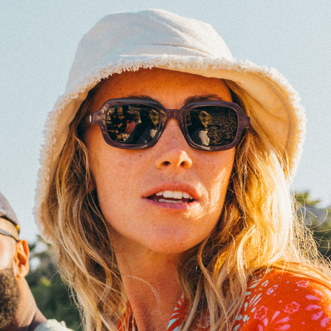 Person wearing a white hat and sunglasses with a blurred background