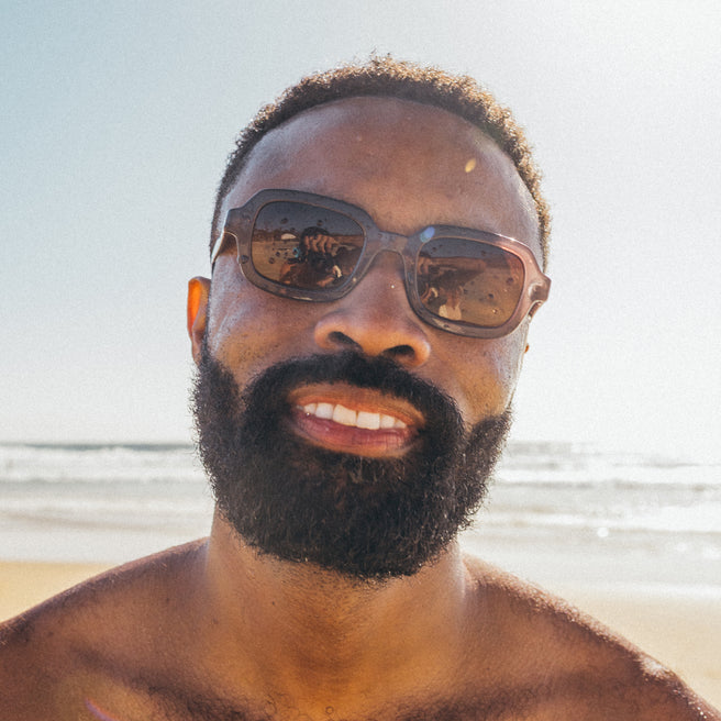 Man wearing sunglasses with a beach background