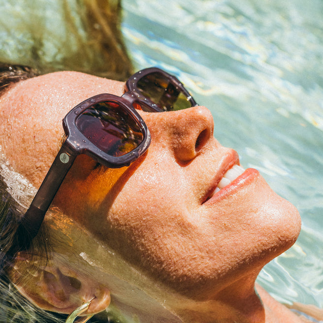 Person wearing sunglasses with a blurred natural background