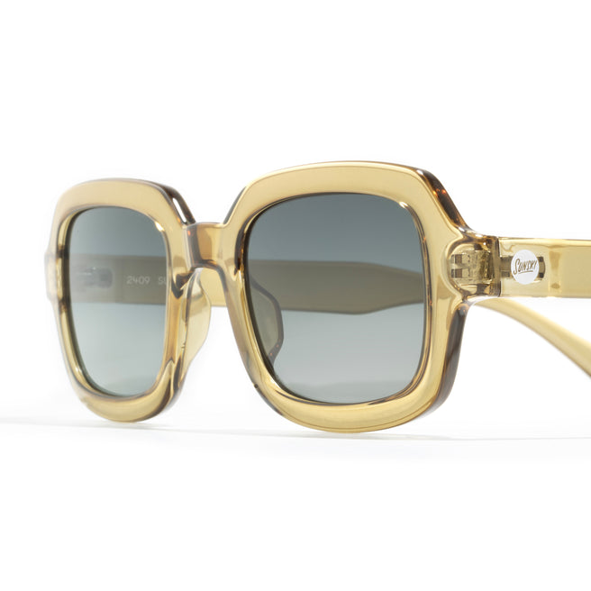 Gold-framed sunglasses with dark lenses on a white background