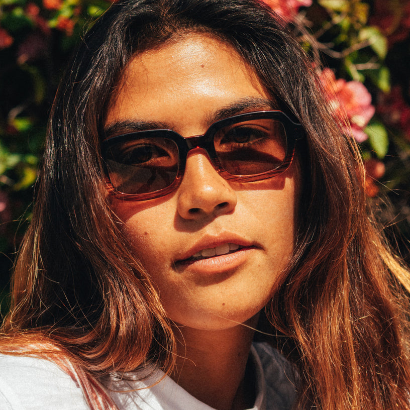 Person wearing sunglasses with a floral background