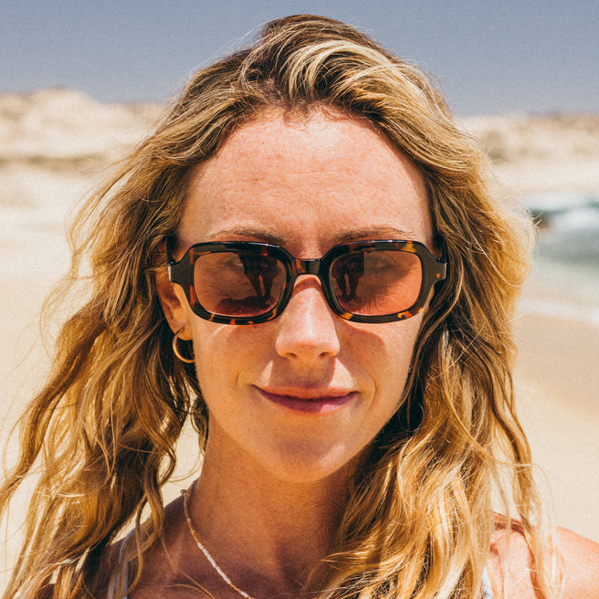 Woman wearing sunglasses with a desert landscape in the background