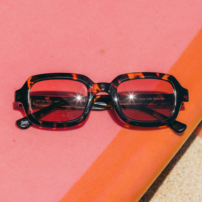 Tortoiseshell sunglasses on a pink and orange background