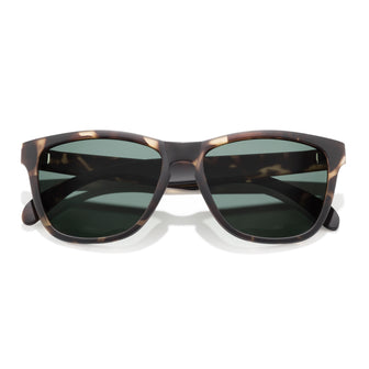 Sunglasses with tortoiseshell frame and dark lenses on a white background