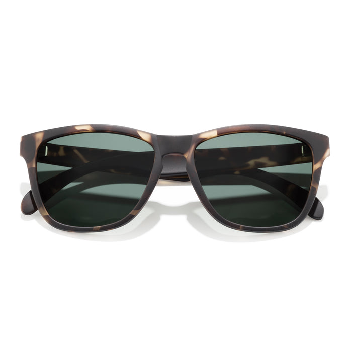 Sunglasses with tortoiseshell frame and dark lenses on a white background