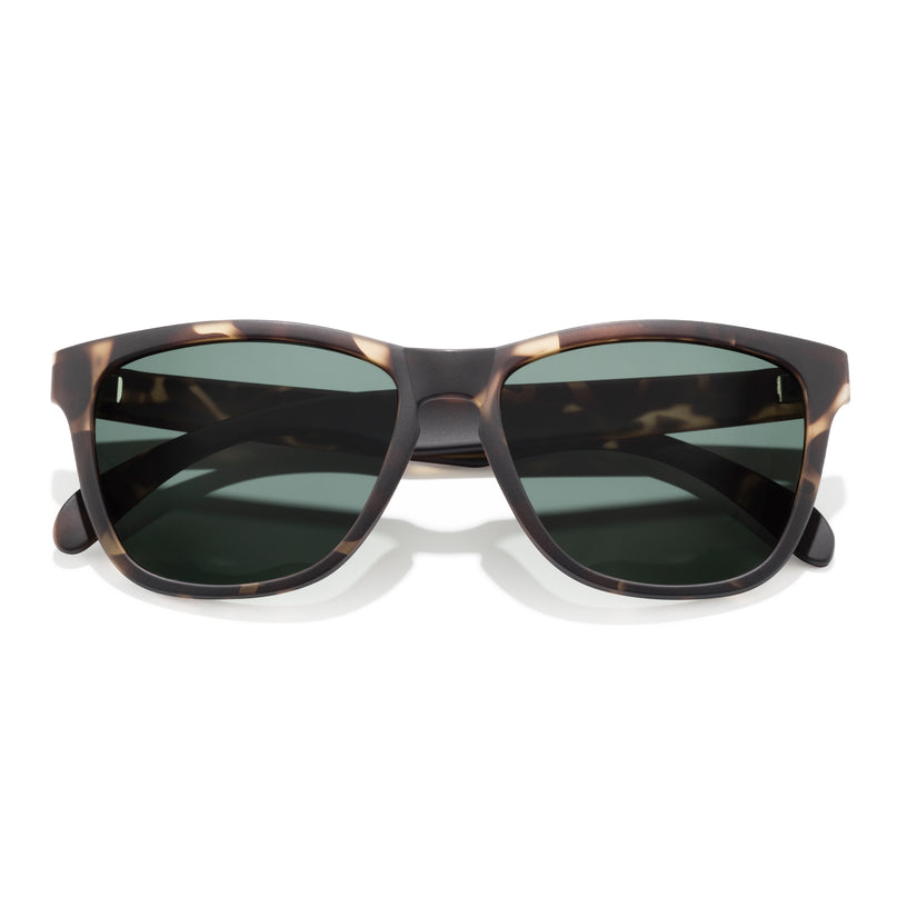 Sunglasses with tortoiseshell frame and dark lenses on a white background