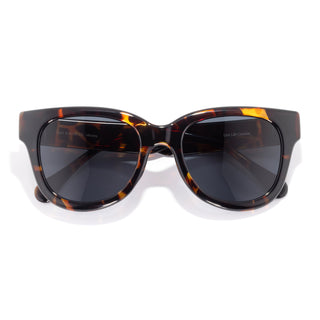Sunglasses with tortoiseshell frame and dark lenses on a white background