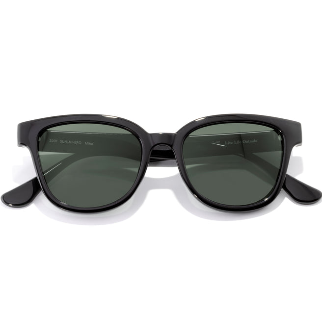 Black sunglasses with green lenses on a white background