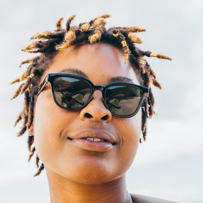 Person wearing sunglasses with a neutral background