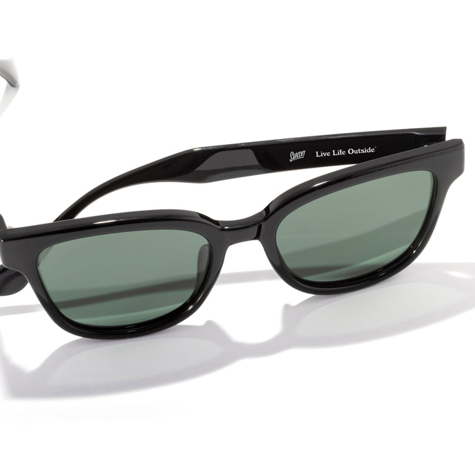 Black sunglasses with green lenses on a white background