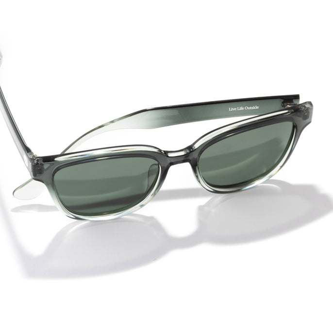 Sunglasses with a clear frame and dark lenses on a white background