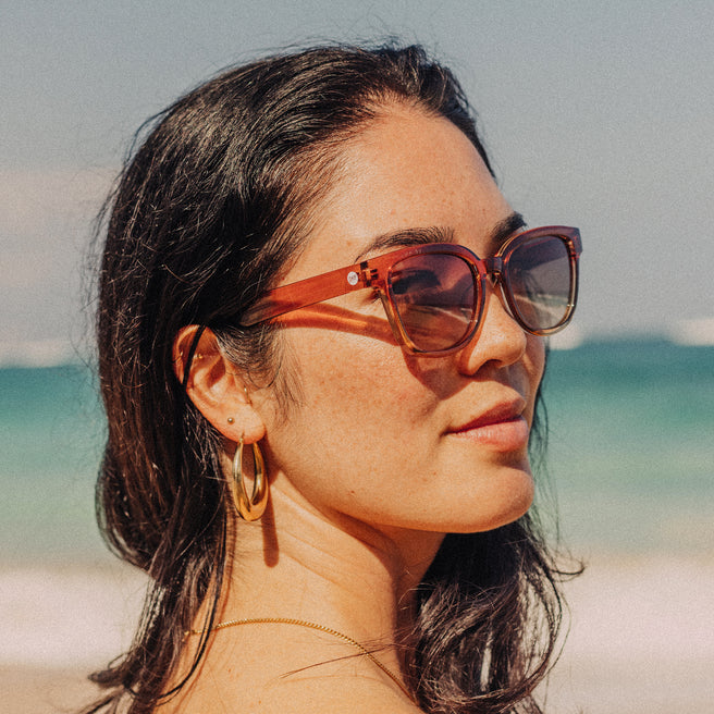 Woman wearing sunglasses with a beach background
