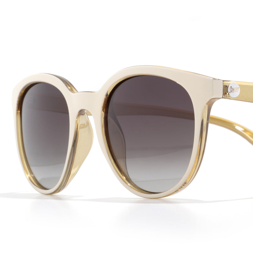 Gold-framed sunglasses with dark lenses on a white background