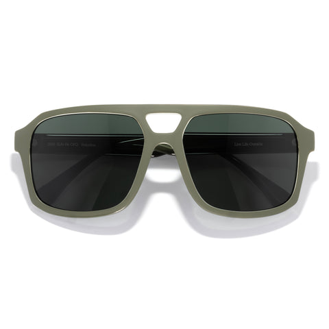 Sunglasses with green frame and dark lenses on a white background
