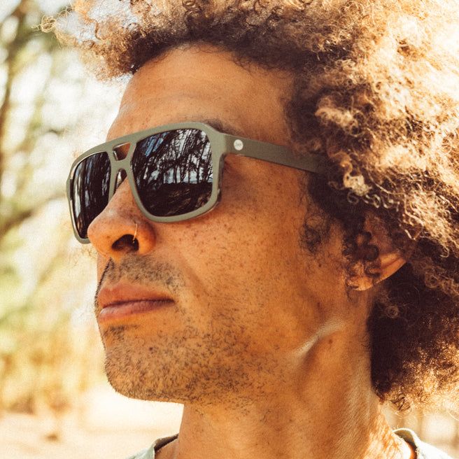 Man wearing sunglasses with a blurred natural background