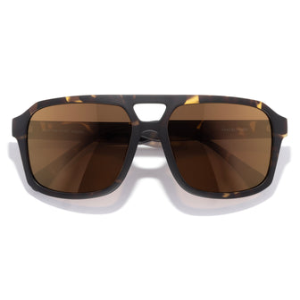 Sunglasses with tortoiseshell frame and brown lenses on a white background