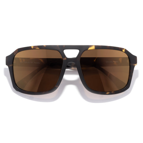 Sunglasses with tortoiseshell frame and brown lenses on a white background