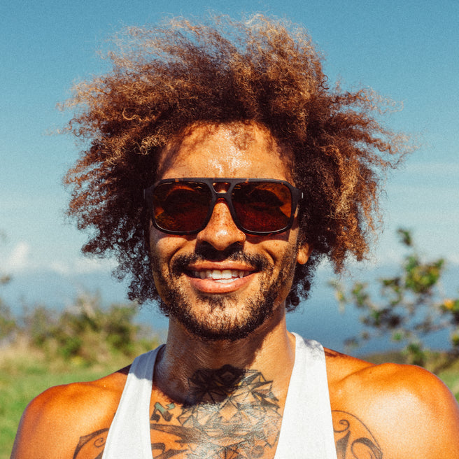 Man with sunglasses and tattoos outdoors on a sunny day