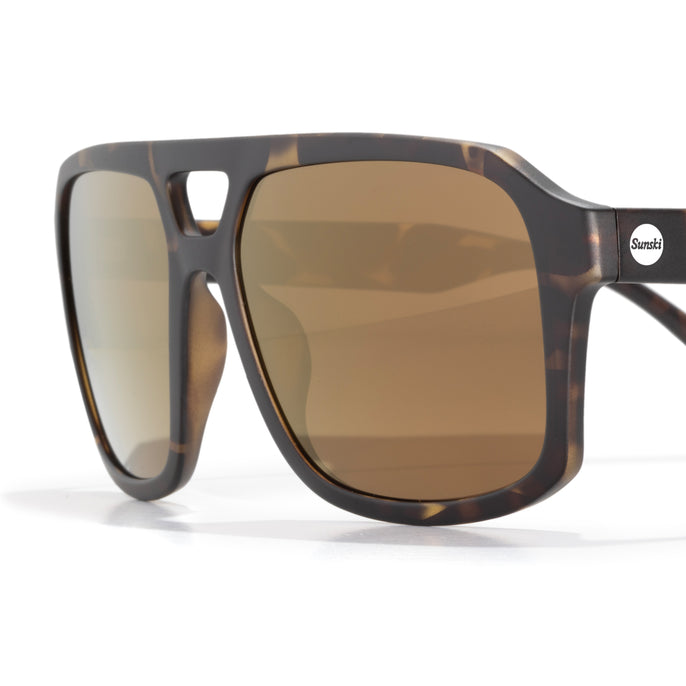 Sunglasses with tortoiseshell frame and brown lenses on a white background