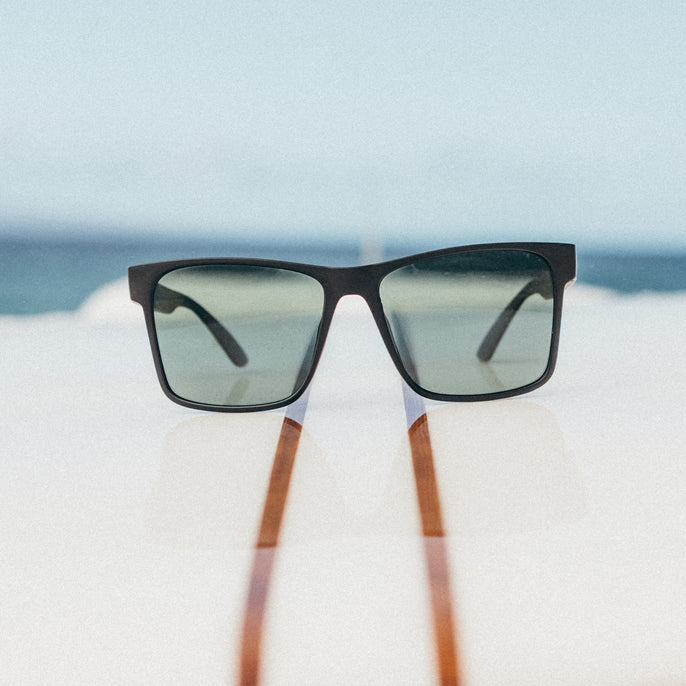 Sunglasses with wooden arms on a blurred beach background