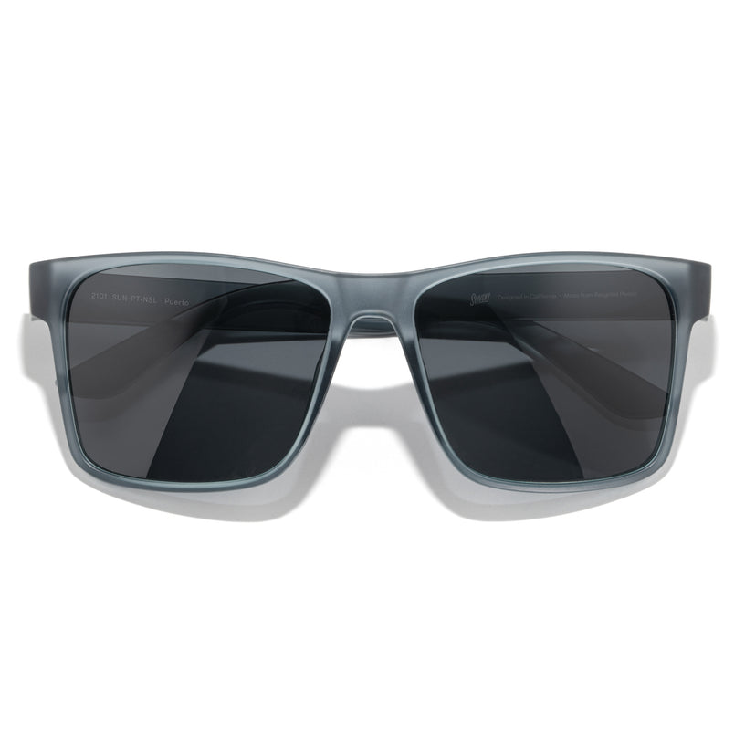 Sunglasses with gray frame and dark lenses on a white background