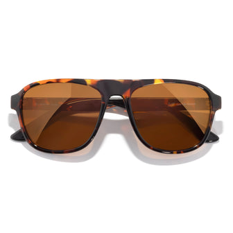 Sunglasses with tortoiseshell frame and brown lenses on a white background