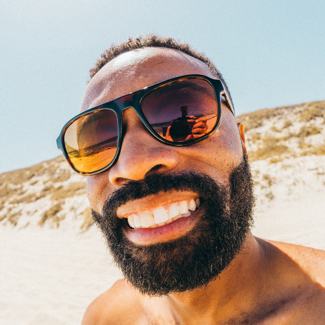 Man wearing sunglasses with a beach background