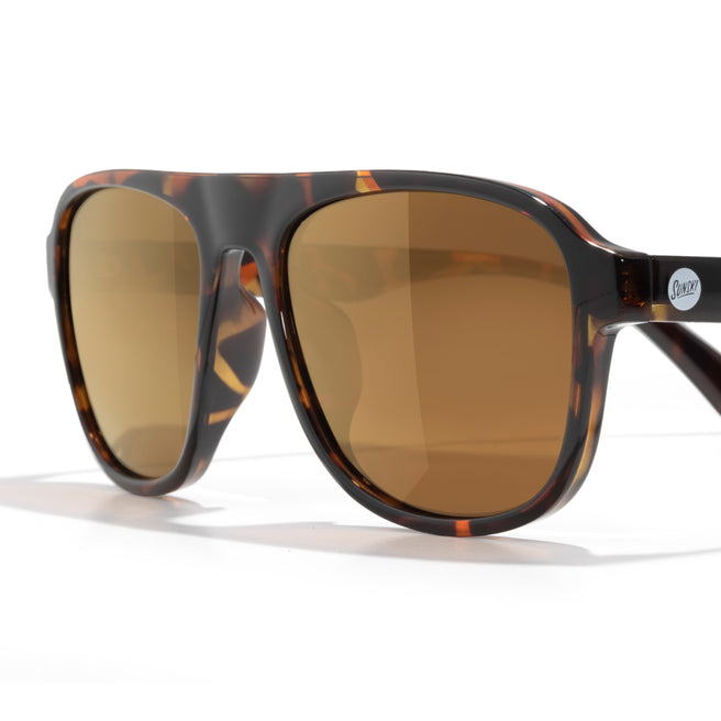 Sunglasses with tortoiseshell frame and brown lenses on a white background