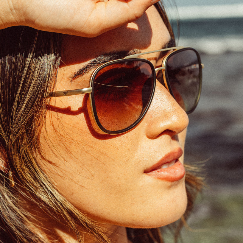 Close-up of a person wearing sunglasses with a blurred natural background