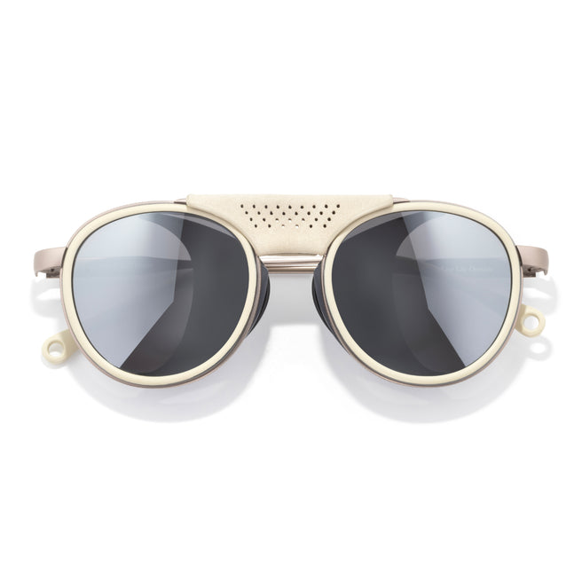 Sunglasses with gold frame and dark lenses on a white background