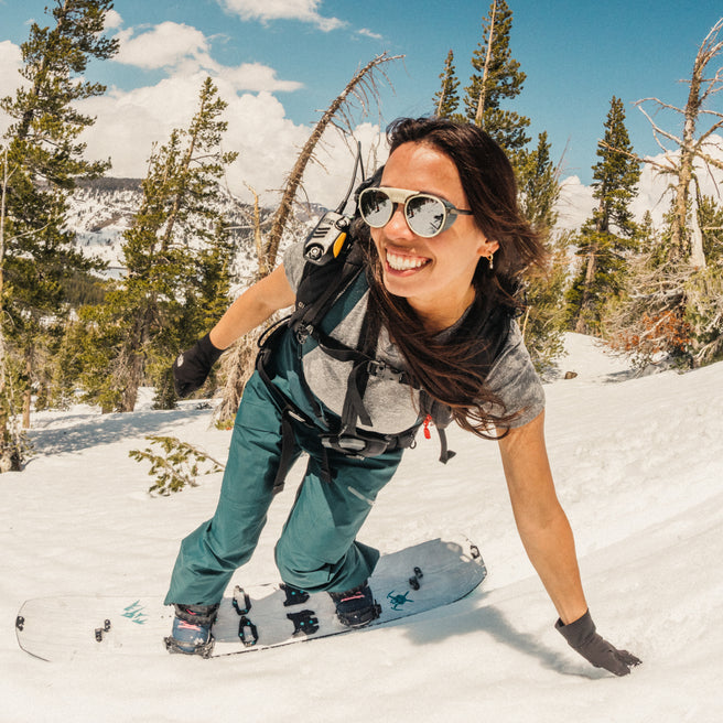 Strada - Ivory Silver - Person snowboarding in a snowy landscape with trees and a clear sky.