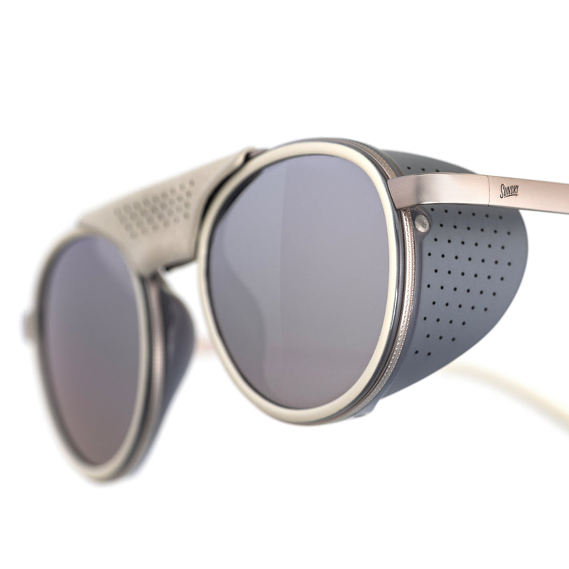 Sunglasses with round lenses and metallic frame on a white background