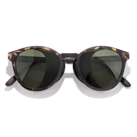 Sunglasses with tortoiseshell frame and dark lenses on a white background