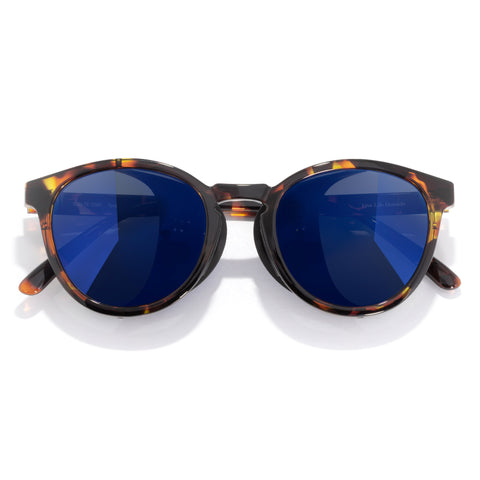 Sunglasses with tortoiseshell frame and blue lenses on a white background