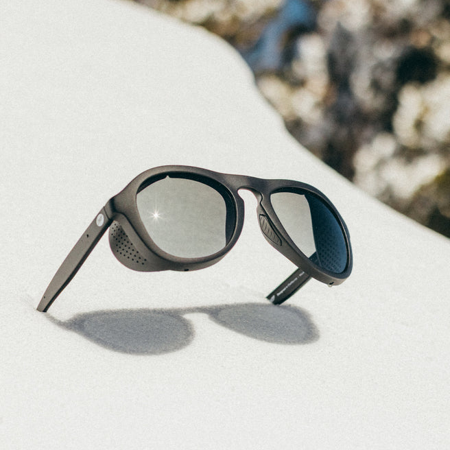 Sunglasses on a white surface with a blurred natural background