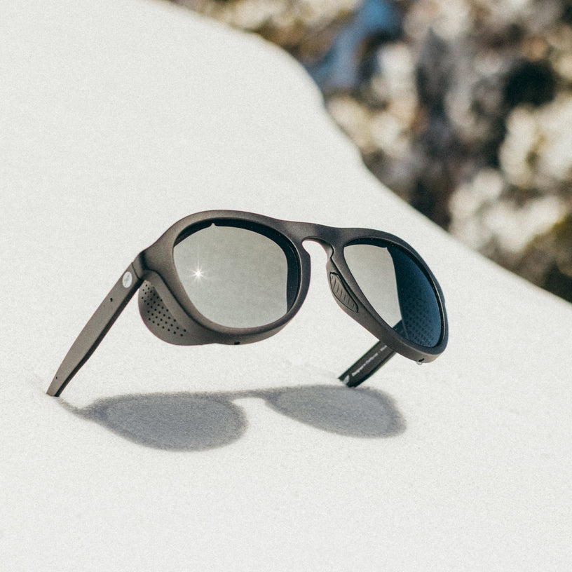Sunglasses on a white surface with a blurred natural background