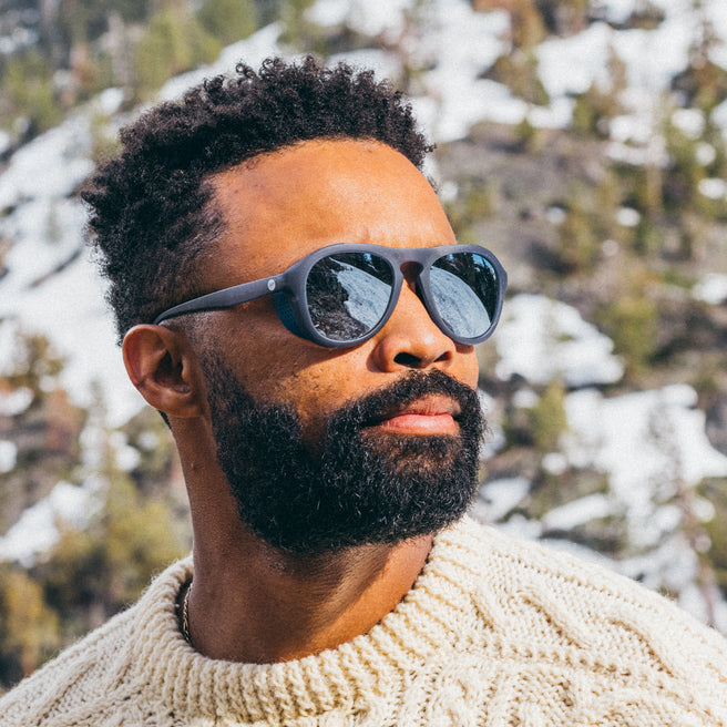 Man wearing sunglasses with a snowy mountain background