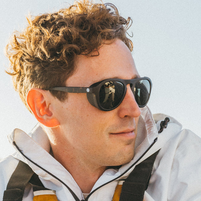 Man wearing sunglasses with a neutral background